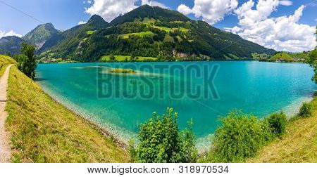 Scenic View Of A Blue Mountain Lake On A Sunny Day. Lungern Switzerland.