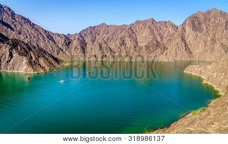Scenic view of Hatta Lake and Hajar Mountains in the Emirate of Dubai, UAE
