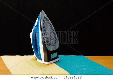 Electrical Iron And Two T-shirts On The Black Mirror Background With A Copy Space