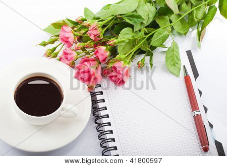 Flowers,cup of coffee and notebook.