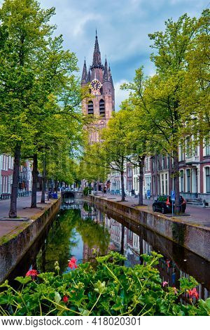 Delt canal with bicycles and cars parked along. Delft, Netherlands
