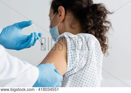 Doctor In Latex Gloves Doing Injection Of Vaccine To African Amercan Woman.
