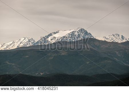 The Snow Capped Peak Of The 2389 Metre High Monte Padru In Corsica With Hills In The Foreground