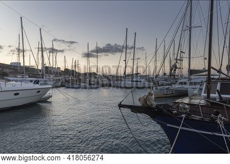 Boats In Vlichada Harbor On Santorini Island In Greece In The Morning At Sunrise. The Background Is 