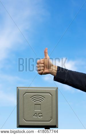 Mimo 4g Antenna With Hand Showing Thumb Up, With Blue Sky On Background.