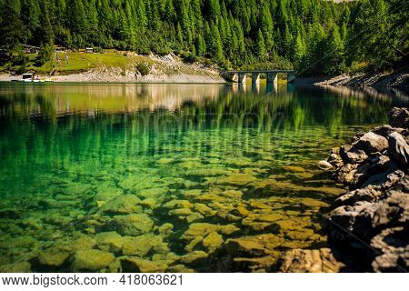 Lake Lago Di Livigno In Livigno, Italy. Lake Reflection.
