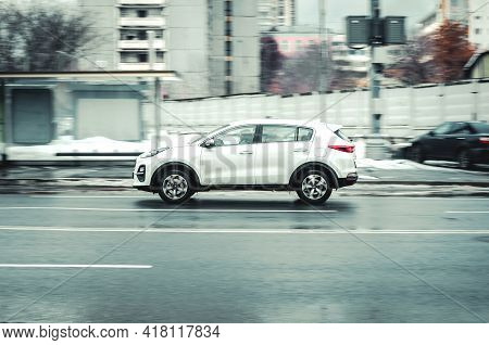 Russia, Moscow - January 2021: Fast Moving Kia Sportage Suv Rides On A Wet City Street. White Crosso