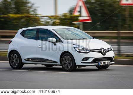 Alanya, Turkey  - April 13  2021:  White  Renault Clio   Is Driving Fast On The Street On A Warm Sum