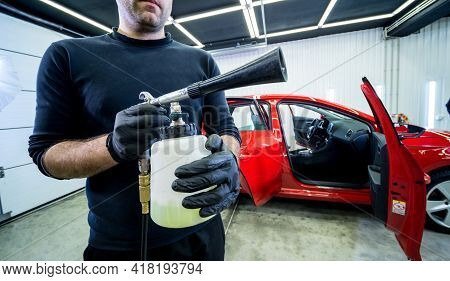 A Car Service Worker Cleans Interiror With A Special Foam Generator