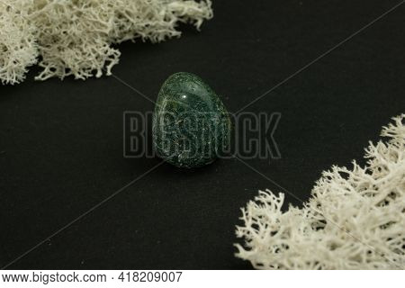 Heliotrope From India. Natural Mineral Stone On A Black Background Surrounded By Moss. Mineralogy, G