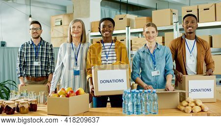 Cheerful Young And Senior Multi-ethnic Charity Organization Workers Males And Females Work At Charit