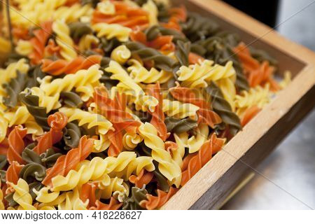 Raw Homemade Tricolor Fusilli Pasta In A Basket.