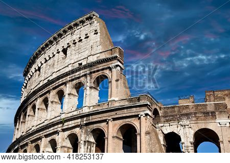 Rome, Italy. Arches Archictecture Of Colosseum (colosseo) Exterior With Blue Sky Background And Clou