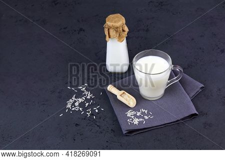 Rice Milk In A Glass Mug And A Bottle On A Dark Grey Background. Vegan Lactose Free. Vegetable Milk.