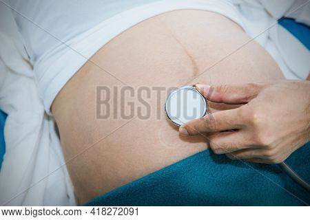 Closeup Of The Hands Doctors Use Medical Headsets To Listen To The Fetus And Develop Infant Movement
