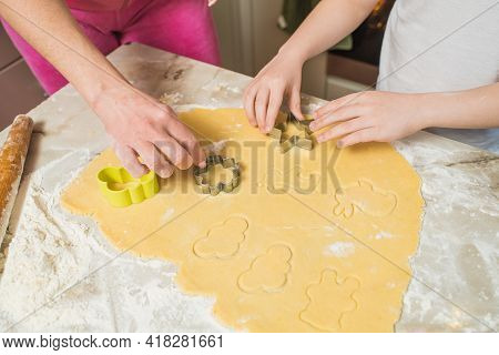 Hands Of Mother And Son Who Squeeze Cookie Figures On The Dough. Cooking At Home