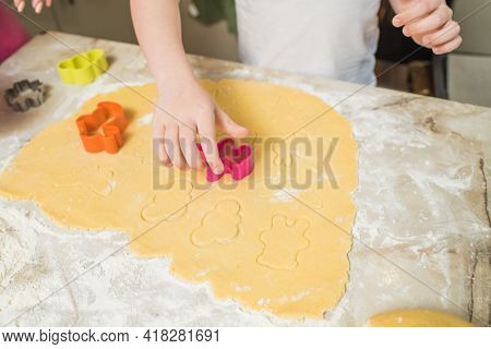 Hands Of Mother And Son Who Squeeze Cookie Figures On The Dough. Cooking At Home