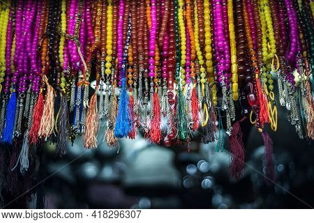 Many assorted Islamic prayers beads hanging in the shop. Muslim religious objects and background.