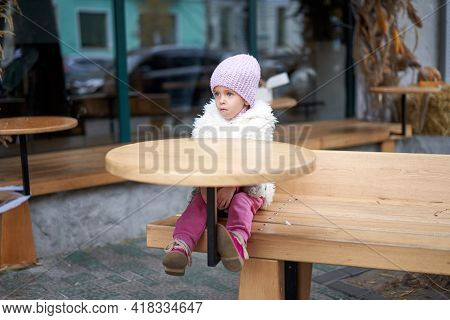 Unhappy Little Girl Sitting Outdoor Cafe At Table Autumn Season Caucasian Female Child Losy In City 