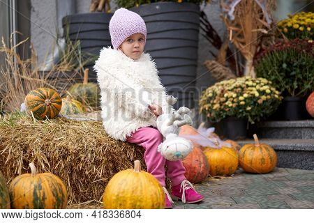 Unhappy Little Girl Sitting Outdoor Halloween Pumpkin With Toy Cat Autumn Season Caucasian Female Ch
