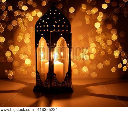 Ornamental Arabic Lantern With Burning Candle Glowing At Night And Glittering Golden Bokeh Lights. F