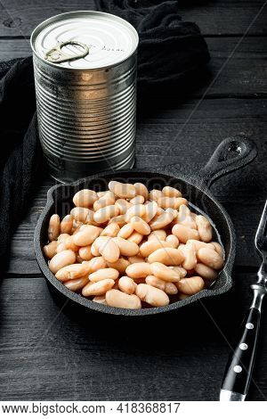 Canned White Beans Set, With Metal Can, In Cast Iron Frying Pan, On Black Wooden Table Background