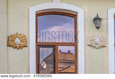 Bas-relief Female Face With Hair On The Wall Of The Facade Of An Ancient Building