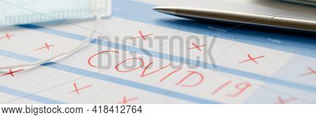 Pen Lying On Table With Calendar With Red Strikethrough Dates During Covid19 Pandemic