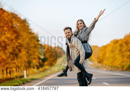 A Happy Couple On An Autumn Road