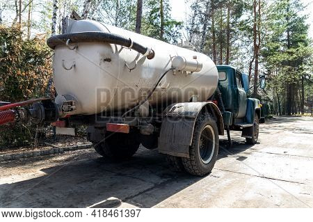 Close-up Pipe Hose Of Sewage Truck Car Engine Emptying Home Sewerage Tank. Septic Cleaning Vacuum Se