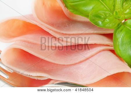 detalle de jamón fresco jugoso con albahaca