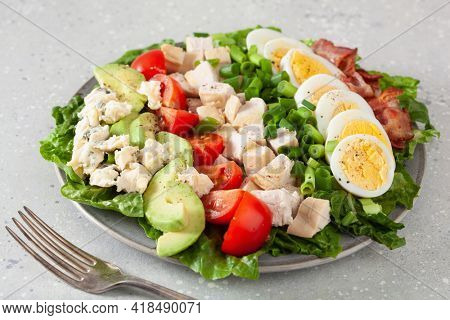 healthy American Cobb salad with egg bacon avocado chicken tomato. hearty keto low carb diet
