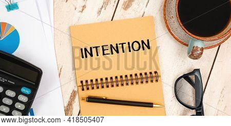 Notebook With Text Intention On The Office Table, Documents, Calculator, Glasses And Pen