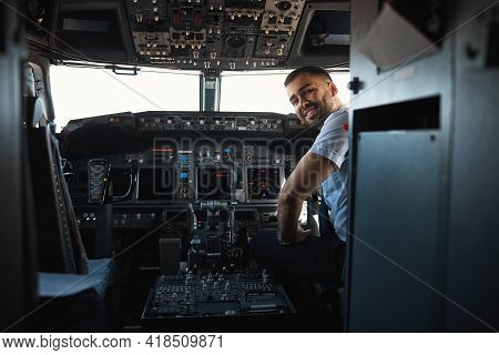 Mirthful Experienced Pilot Looking Happy At His Workplace