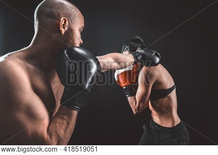 Shirtless Woman Exercising With Trainer At Boxing And Self Defen
