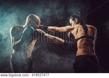 Shirtless Woman Exercising With Trainer At Boxing And Self Defen