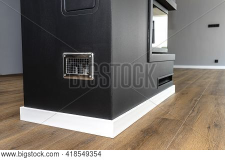 Inspection Door And Condensate Tank Behind The Grille In A Modern Fireplace With A Closed Combustion