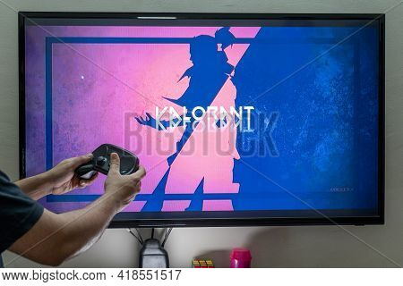 Man Holding Steam Controller In Front Of A Screen Loading Valorant On Pc Console For Gaming Showing 
