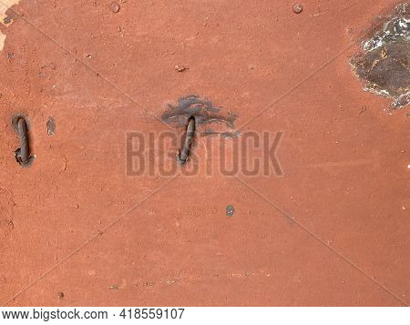 Rusty Old Metal Wall, Rusty Crooked Nails. Nails Are Driven Into The Metal Wall. Old Paint Job