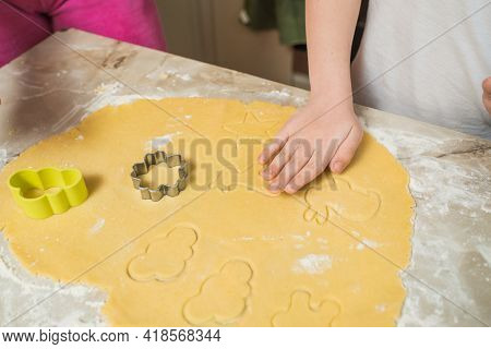 Hands Of Mother And Son Who Squeeze Cookie Figures On The Dough. Cooking At Home