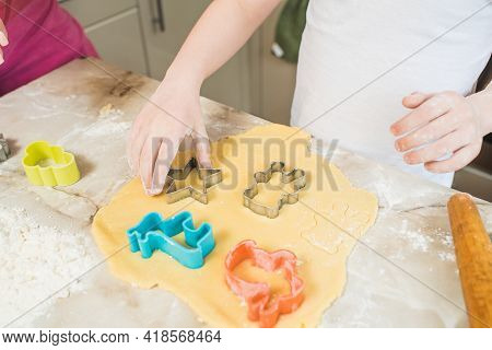 Child's Hands Squeezing Cookie Figures On The Dough. Cooking At Home