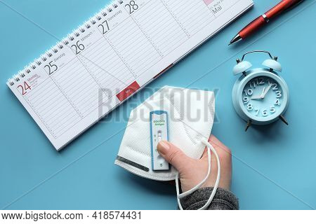 Week Planner, Schnelltest, Rapid Corona Test In German Language. Flat Lay With Hand Holding Express 