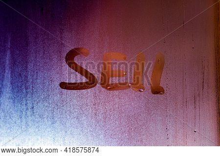 The Word Sell Handwritten On Night Wet Window Glass Surface