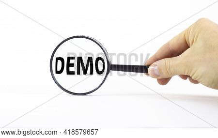 Demo Symbol. Magnifying Glass With Word Demo On A Beautiful White Background. Businessman Hand. Busi