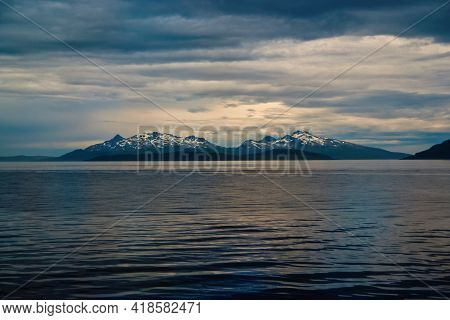 Sea In Hammerfest, Norway. Evening Seascape With Mountain Coast Under Cloudy Sky. Sea Travelling. Ad