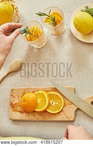 Female Hand Put Rosemary In Glasses, Making Fresh Lemonade