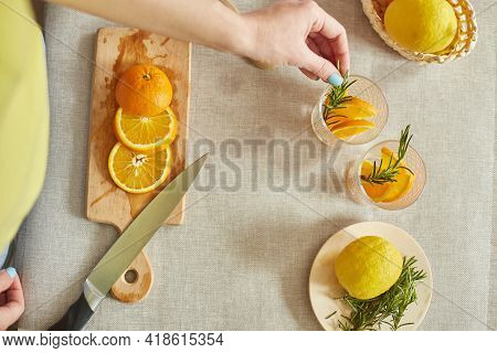 Female Hand Put Rosemary In Glasses, Making Fresh Lemonade