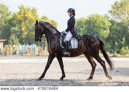 Young Girl Riding Horse At Dressage Advanced Test