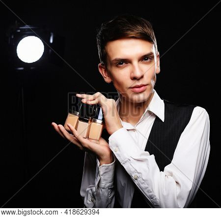 Young male make up artist posing with foundation for make-up o