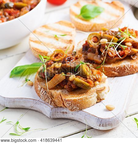 Traditional Italian Caponata And Toast On A Wooden White Table. Sicilian Caponata.